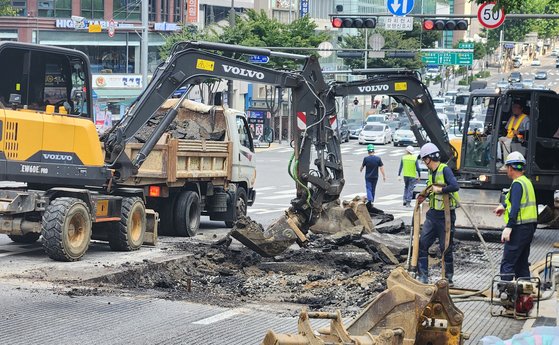 지난 12일 땅 꺼짐 현상이 발생한 서울 강남구 봉은사로에서 관계자들이 복구공사를 진행하고 있는 모습. 19일 내려앉은 도로는 이 지점의 반대 방향 차로다. 연합뉴스